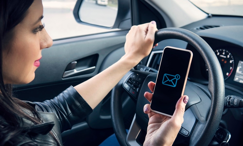 Femme avec le téléphone en main au volant