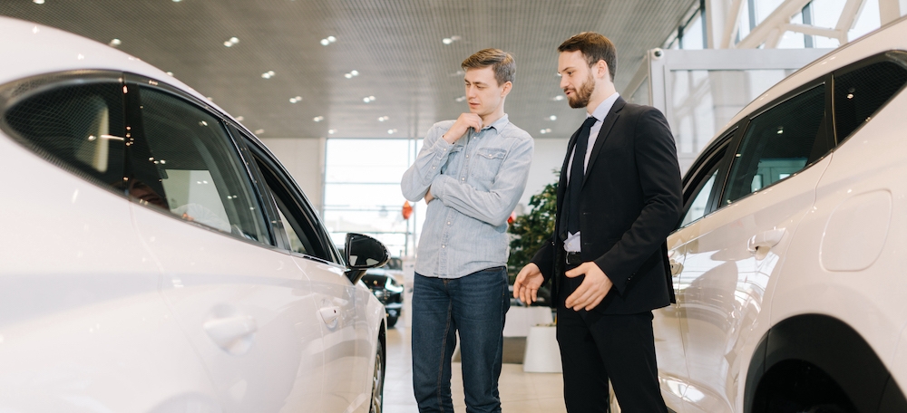 Un homme choisissant une voiture chez un concessionnaire